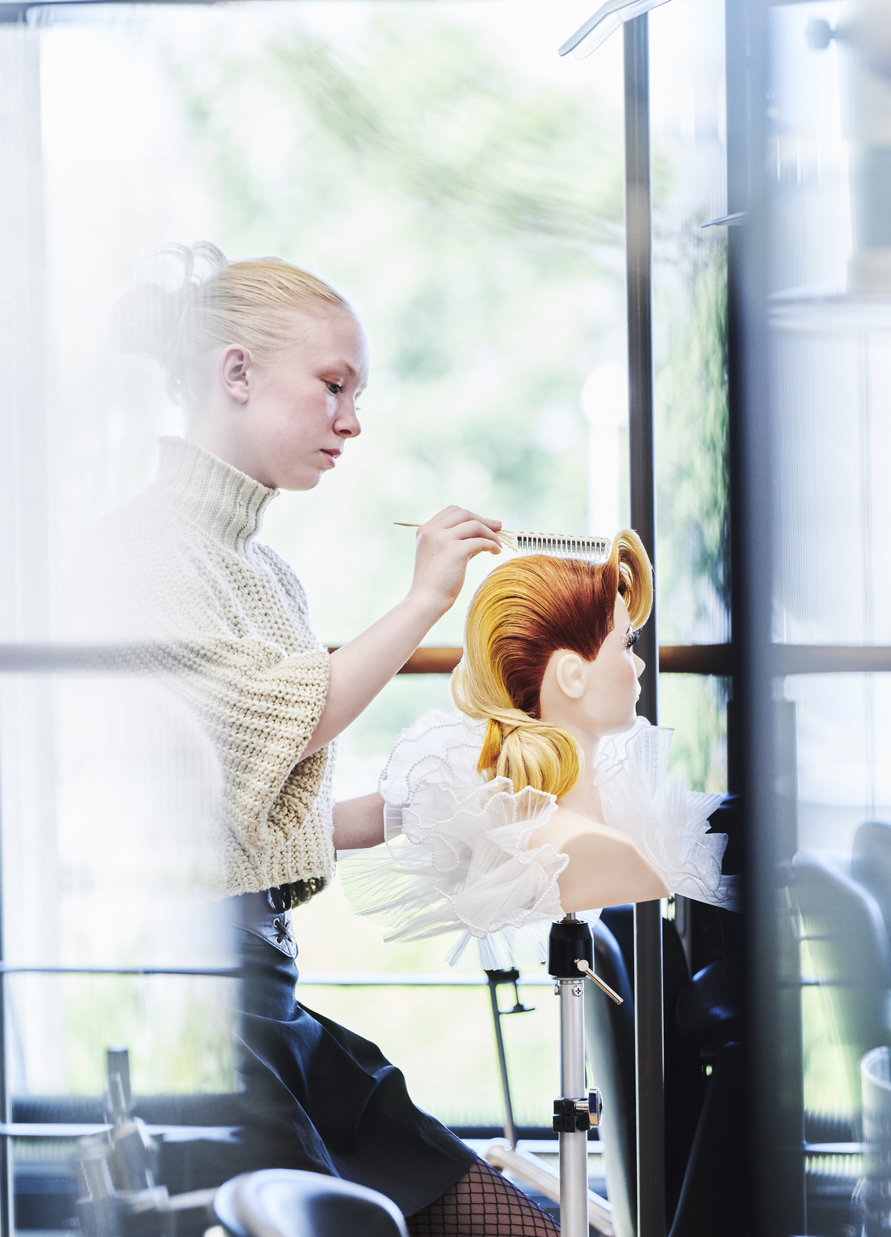 Elev laver frisure på øvelseshovede