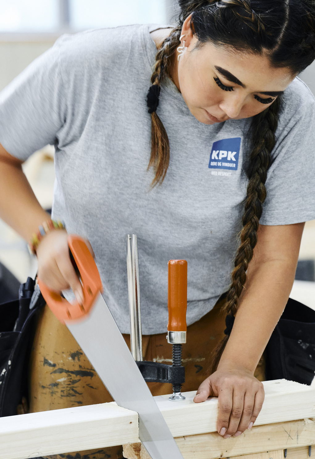 Pige i arbejdstøj saver