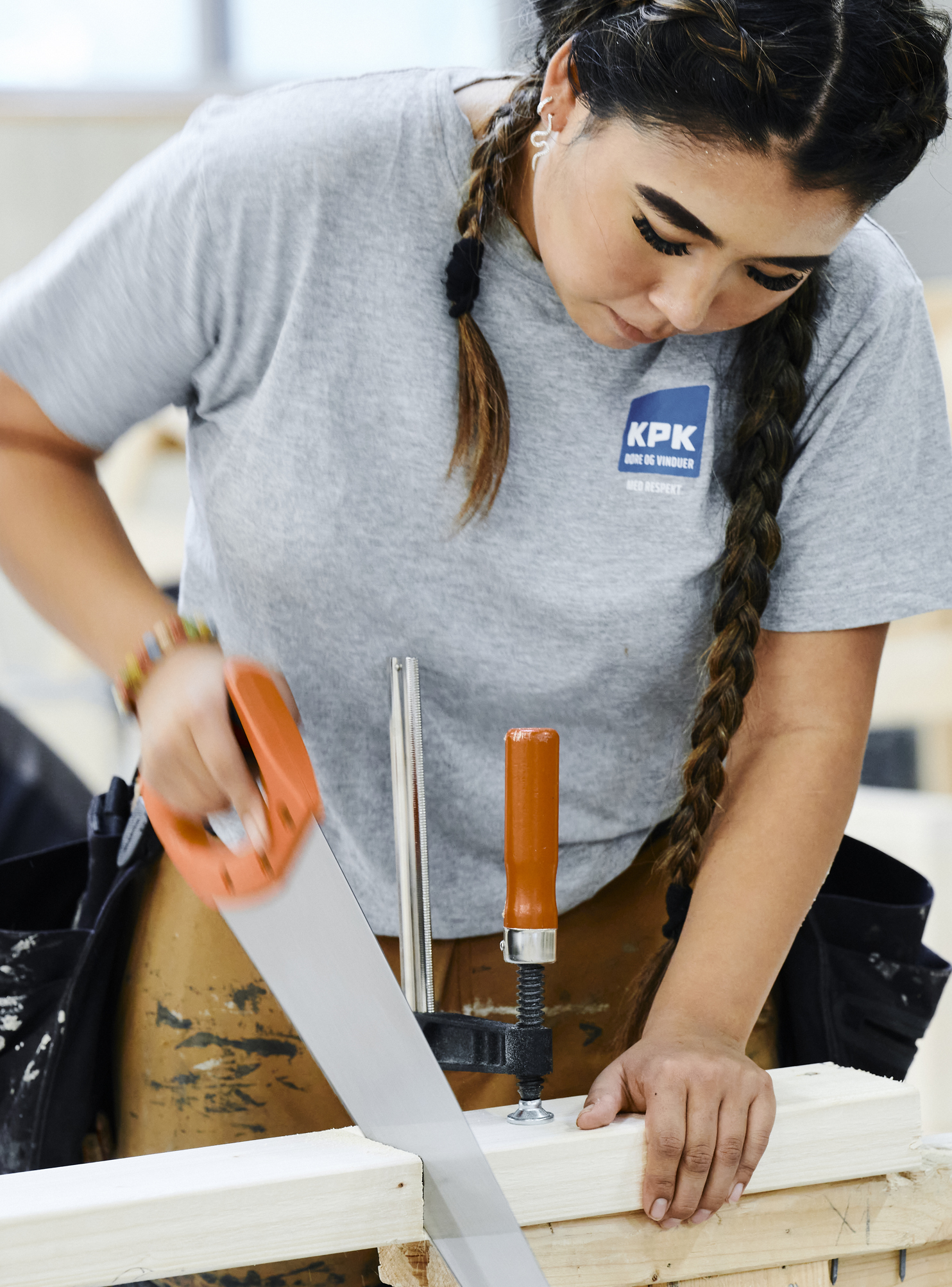 Pige i arbejdstøj saver