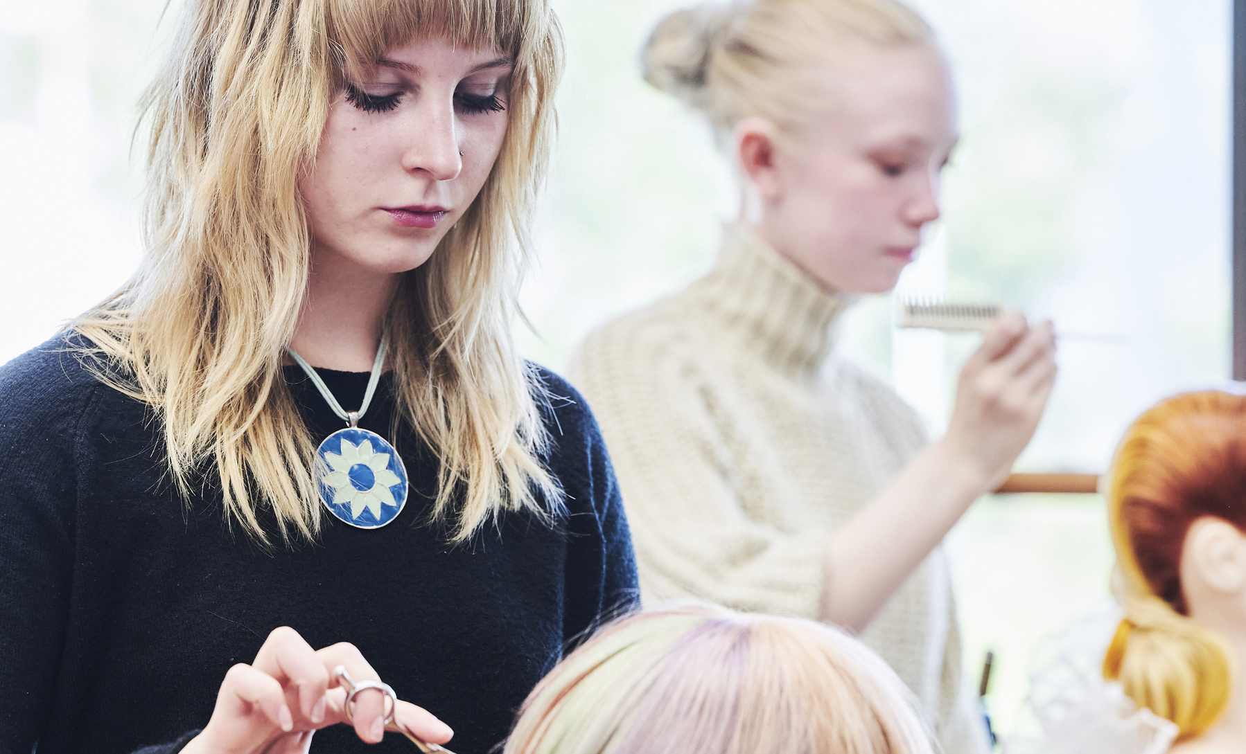 Elev klipper hår på øvelseshovede