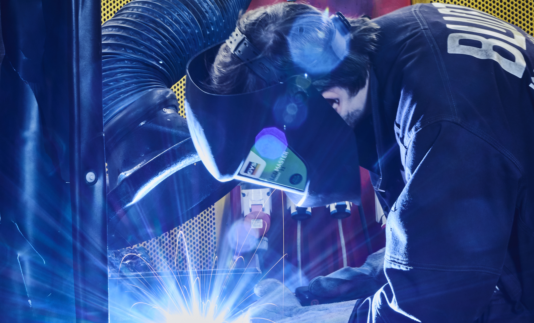 Smedeelev svejser i svejsekabine 