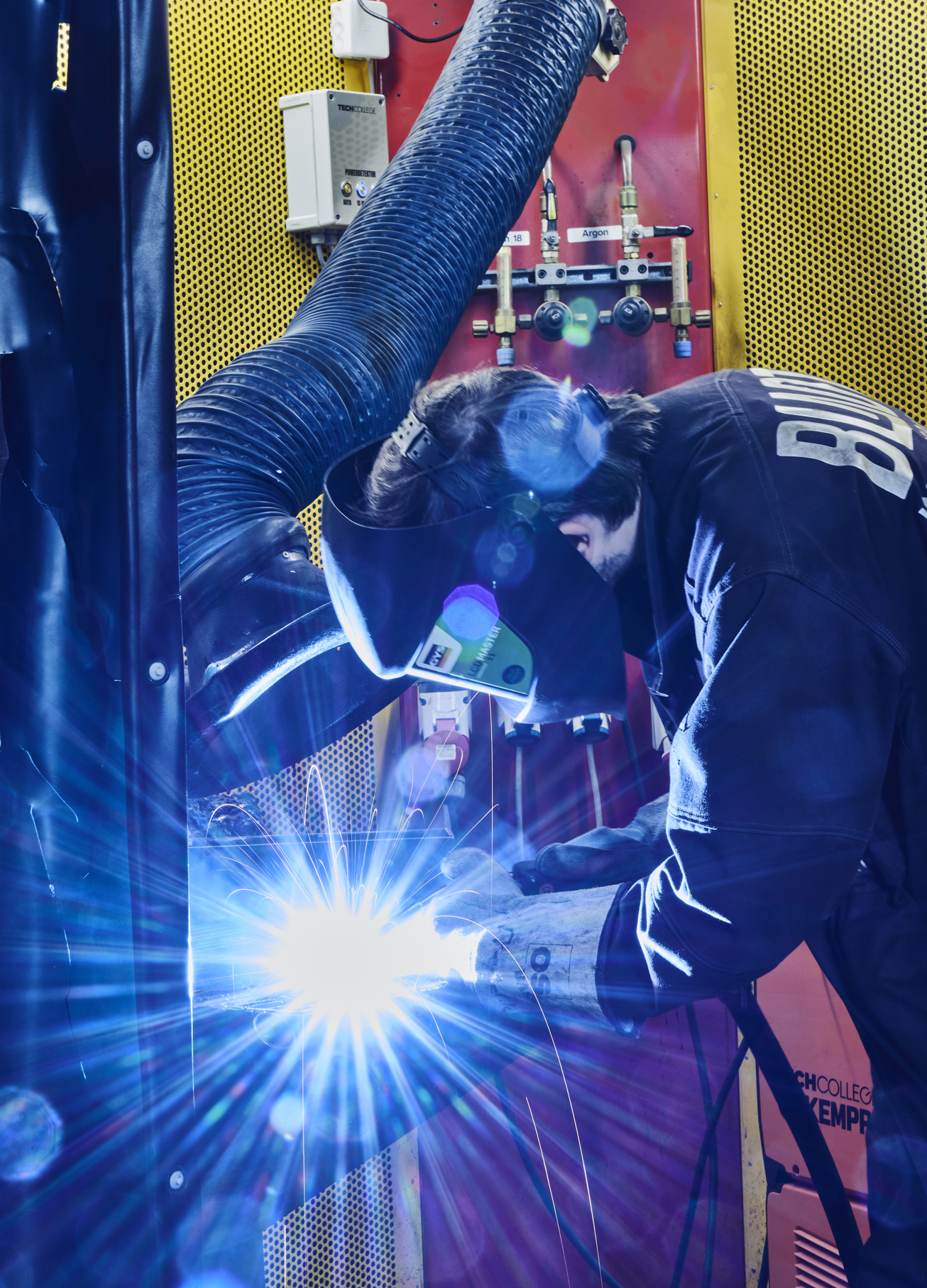 Smedeelev svejser i svejsekabine 