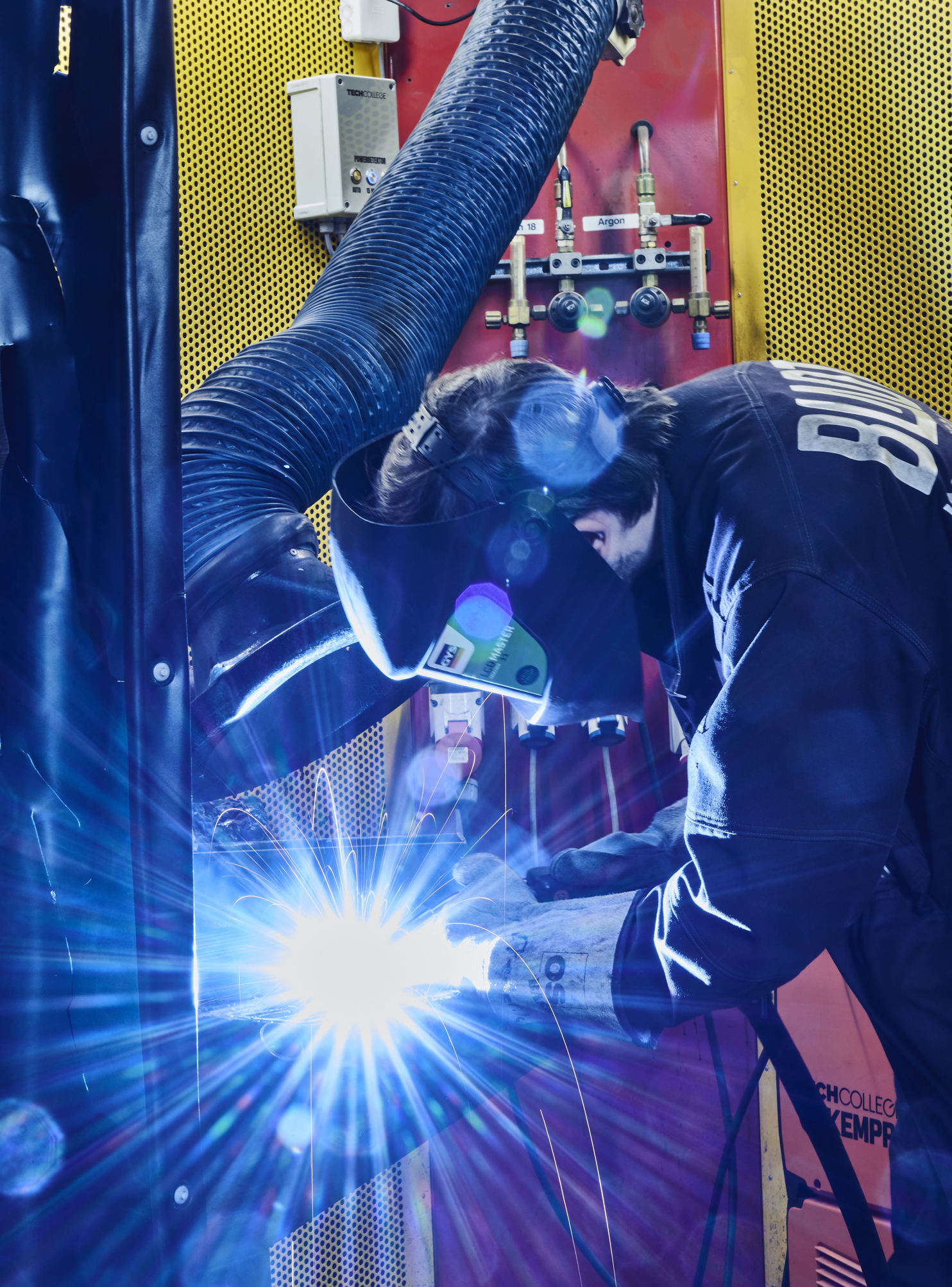 Smedeelev svejser i svejsekabine 