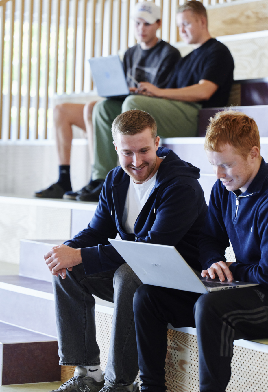 Elever sidder i studiemiljø med computere