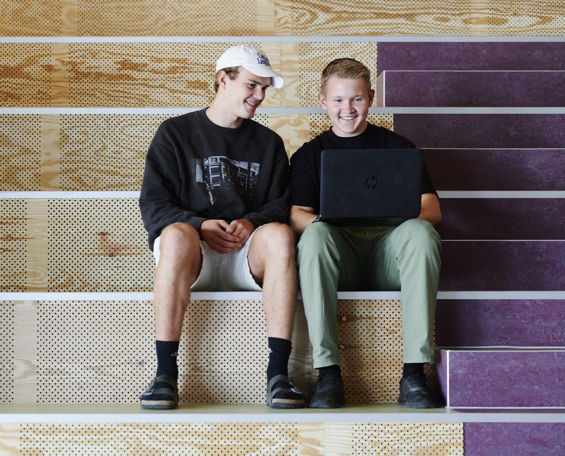 Elever sidder i studiemiljø med computer