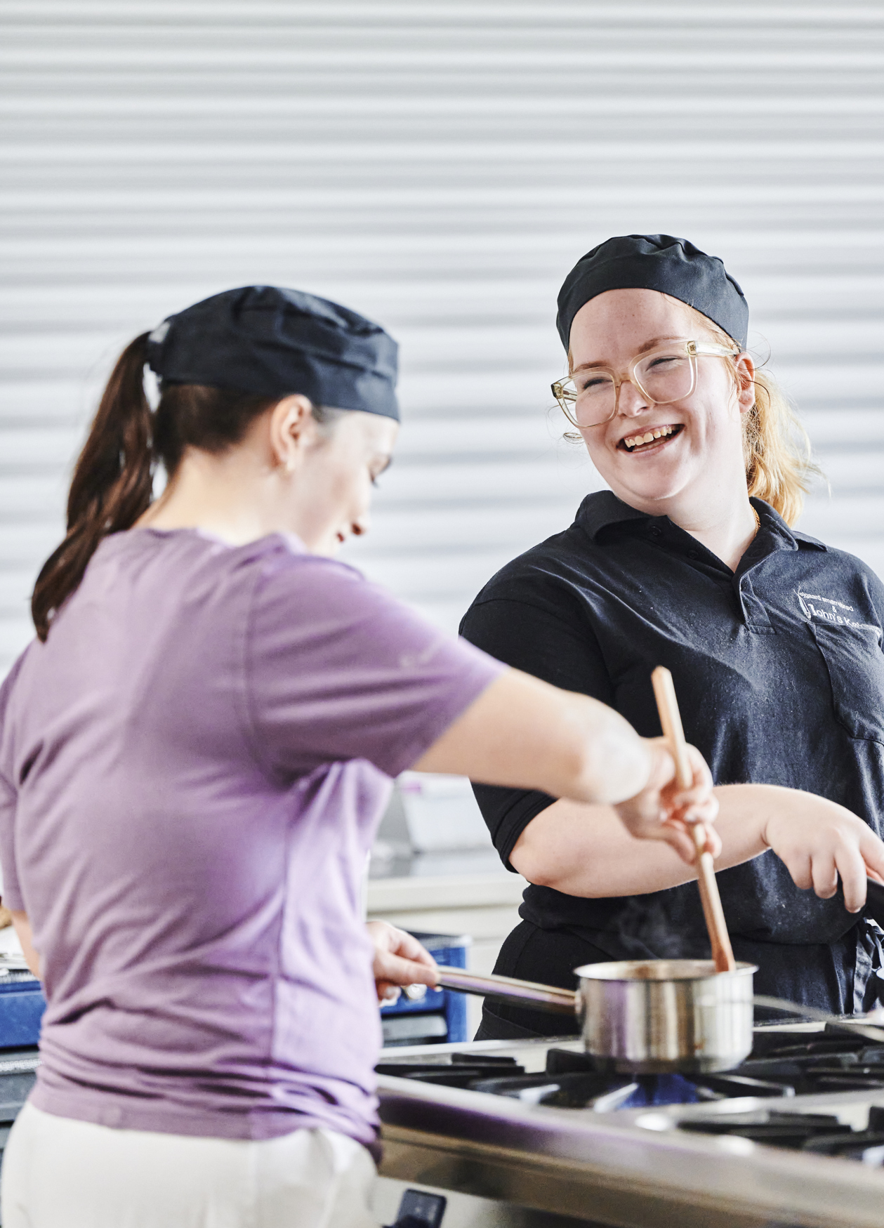 Ernæringsassistenter griner sammen i køkkenet