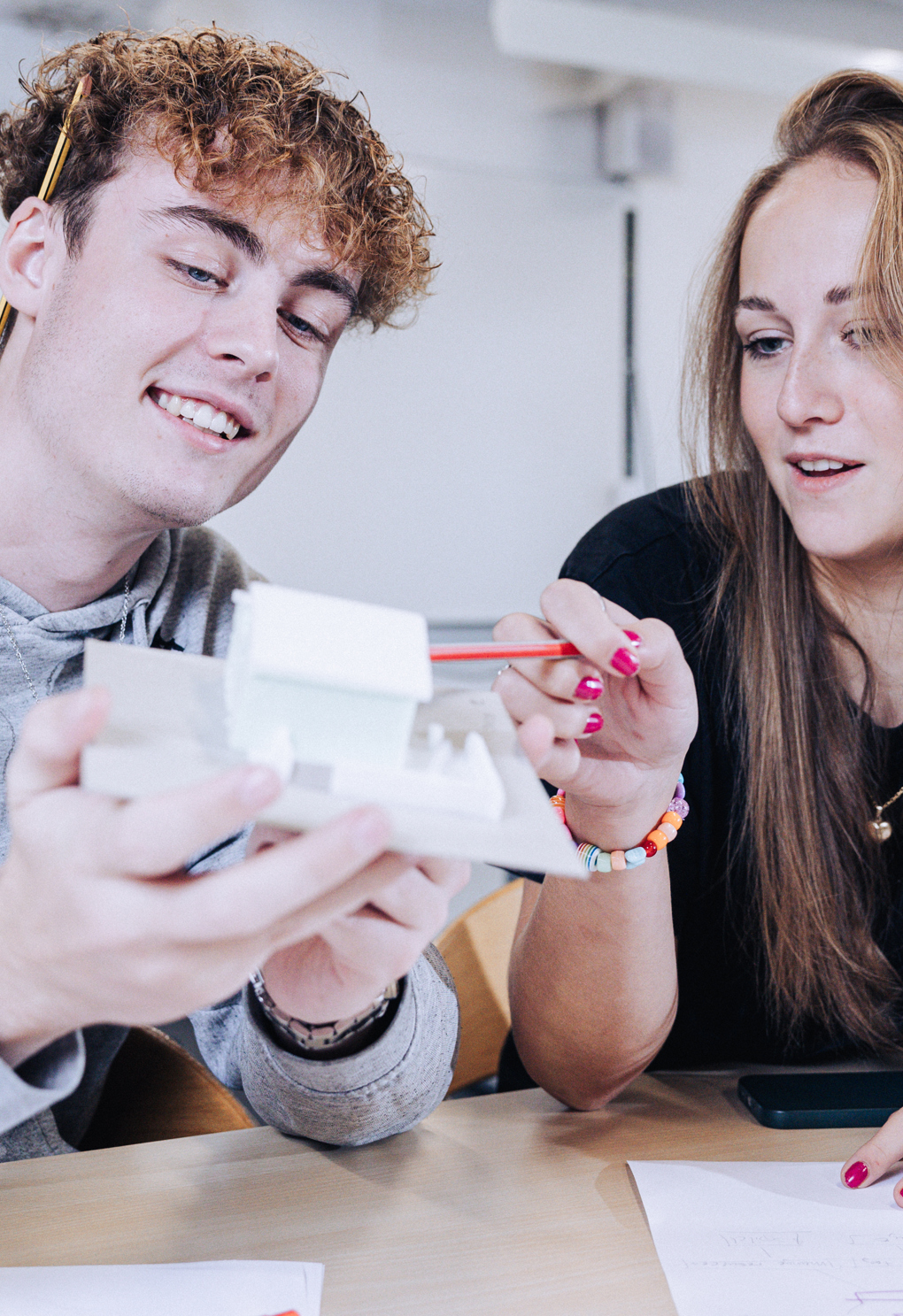 Innovation og teknologi, elever sidder med model af et hus