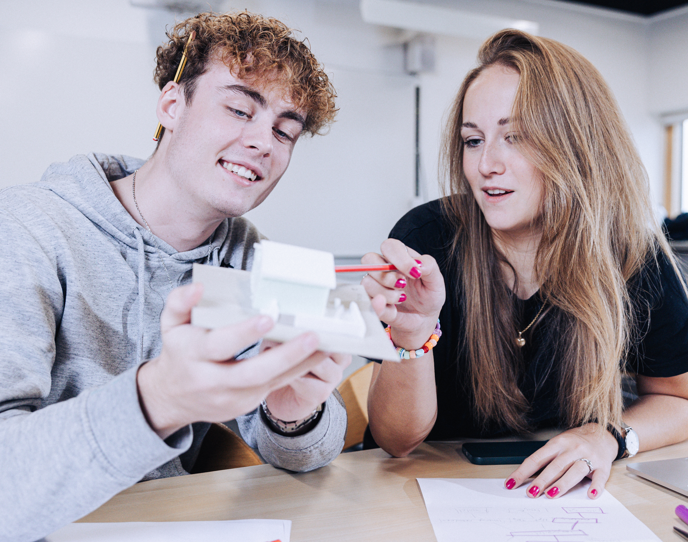 Innovation og teknologi, elever sidder med model af et hus