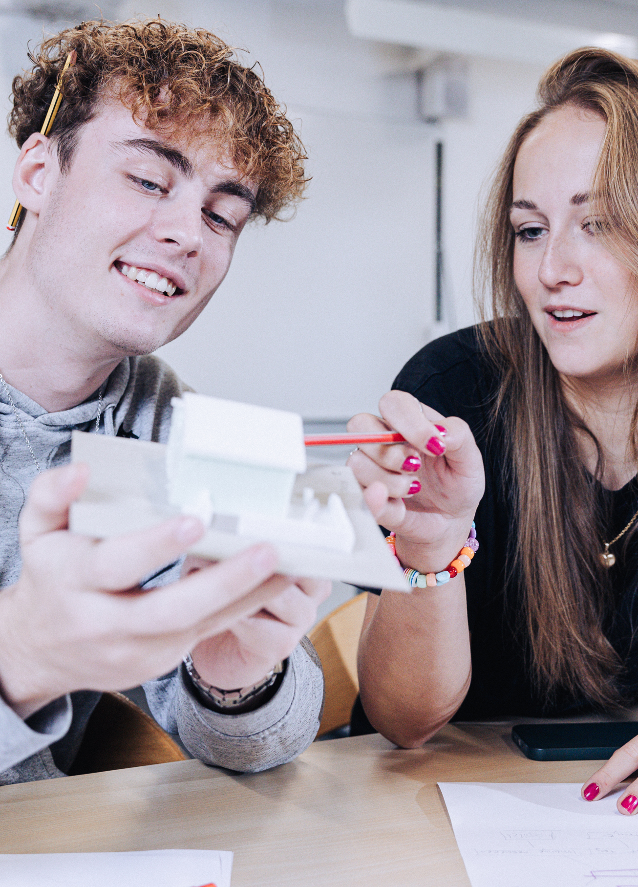 Innovation og teknologi, elever sidder med model af et hus