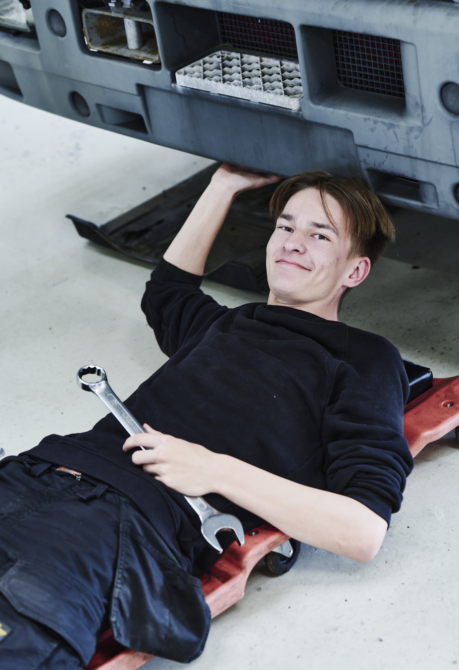 Lastvognsmekaniker-elev kigger op fra rullebræt