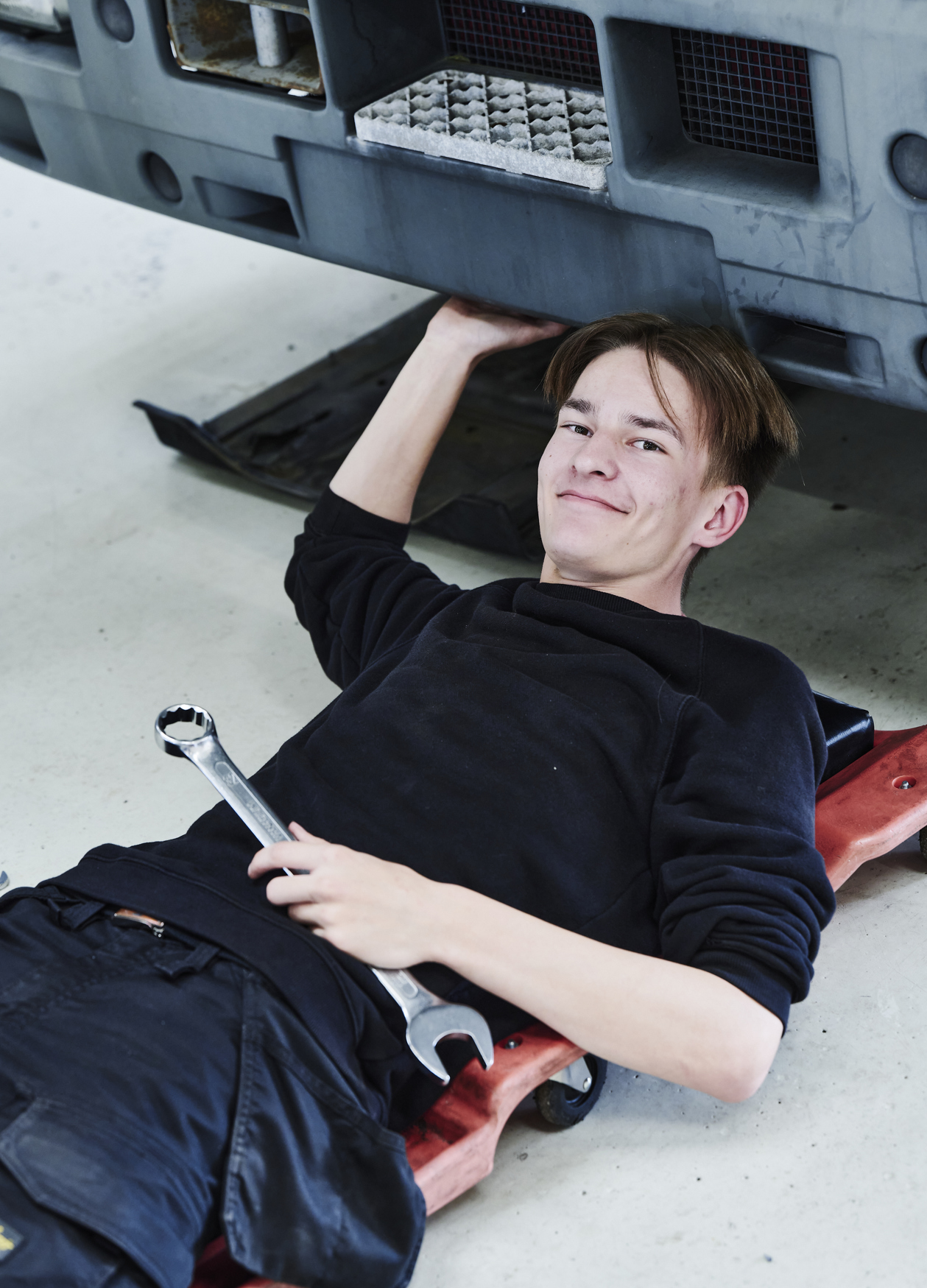 Lastvognsmekaniker-elev kigger op fra rullebræt